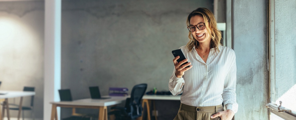 Juristin im Büro während eines Video Calls mit ihrem Handy