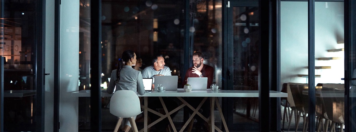 Drei Personen bei Nacht im Büro