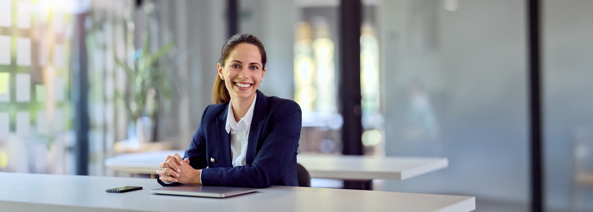 Lächelnde Anwältin an einem Tisch in einem modernen Büro