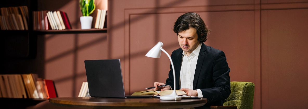 Jurist liest an seinem Schreibtisch das StGB