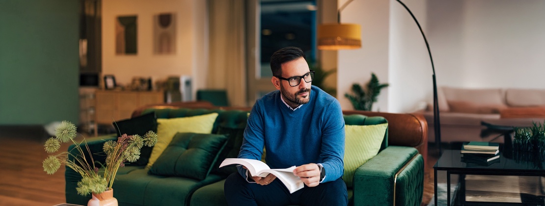 Junger Jurist liest das BGB auf einem Sofa