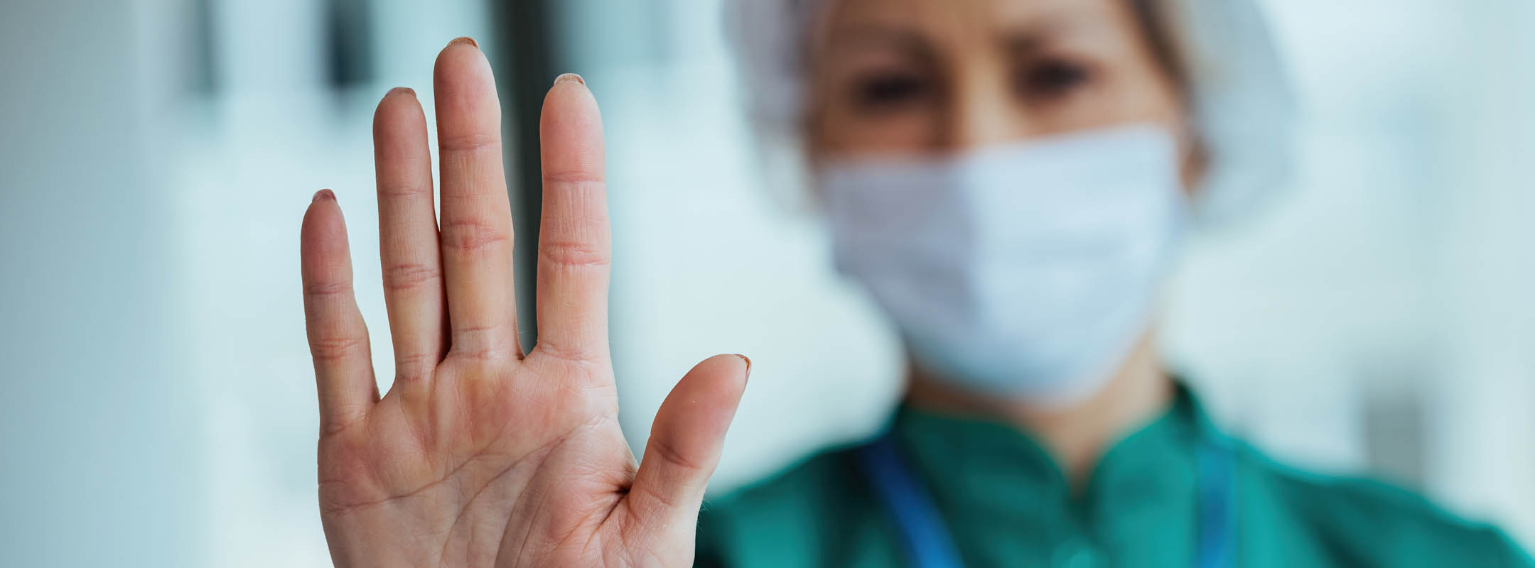 Eine Krankenschwester hebt ihre Hand ablehnend nach oben.