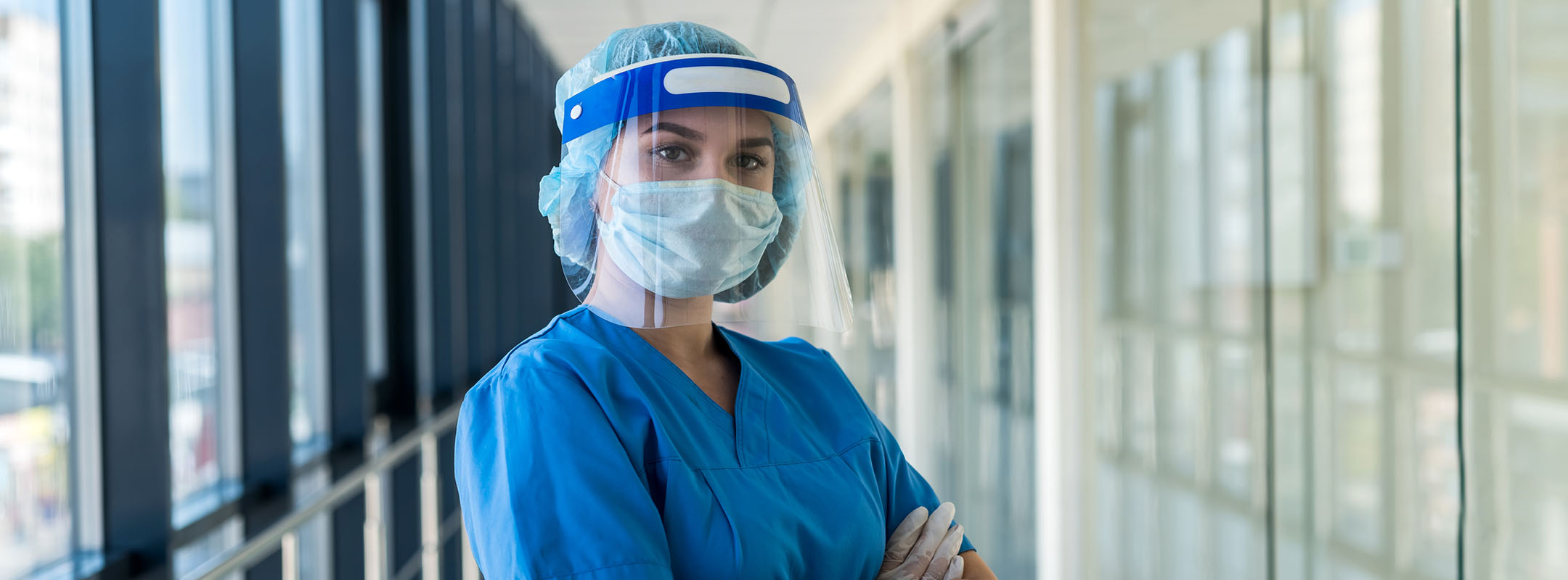 Eine Krankenschwester mit Visier, Atemschutzmaske und Handschuhen