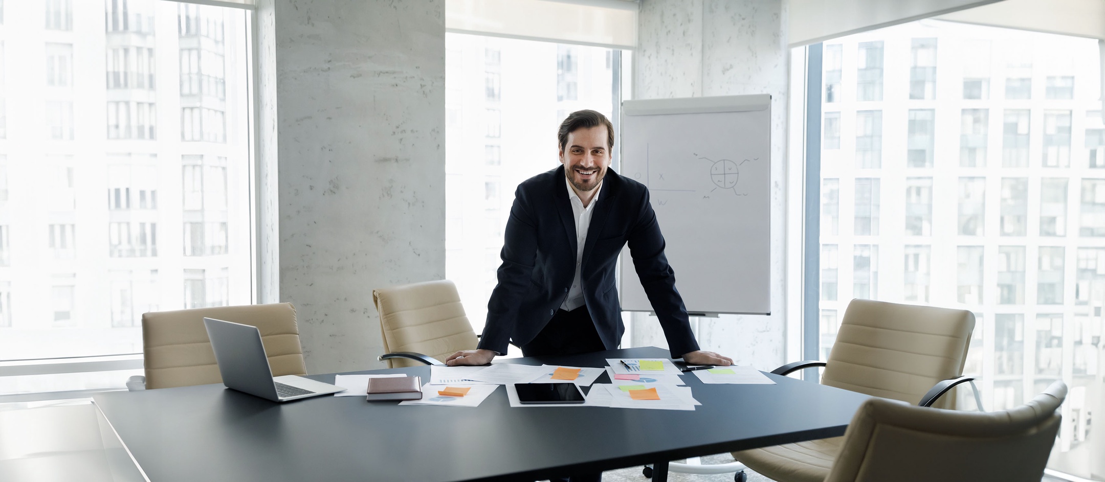 Mann in verglastem Büro an Schreibtisch