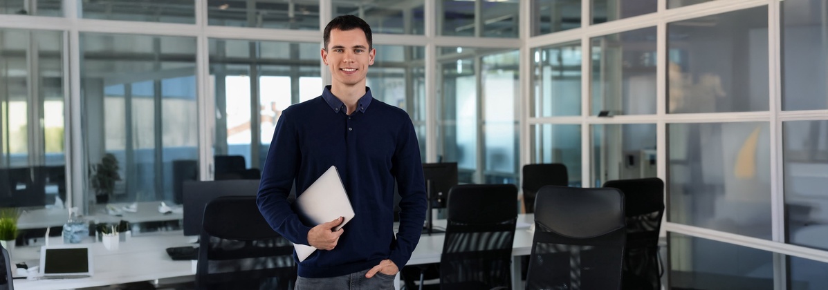 Junger Mann mit Laptop im Büro