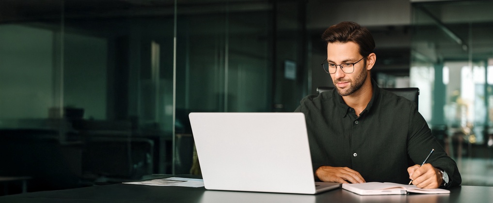 Junger Jurist am Laptop schreibt Notizen